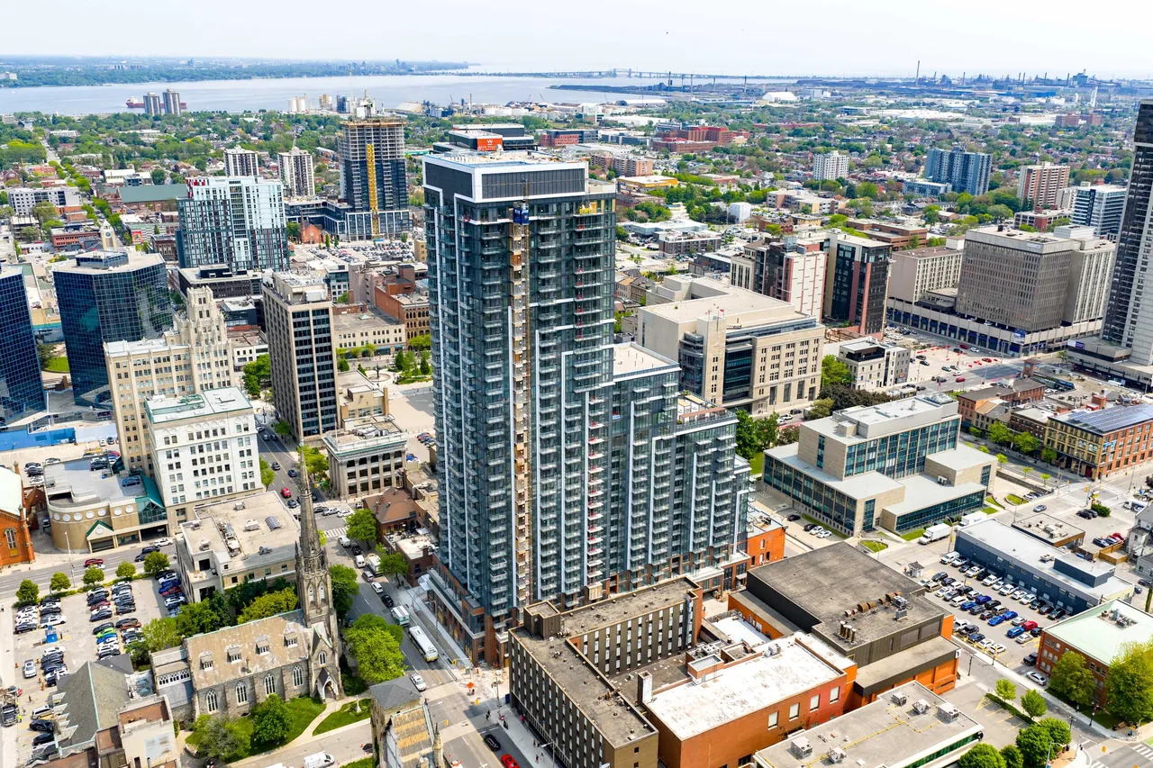 Aerial view of a downtown residential tower with the city and lake behind